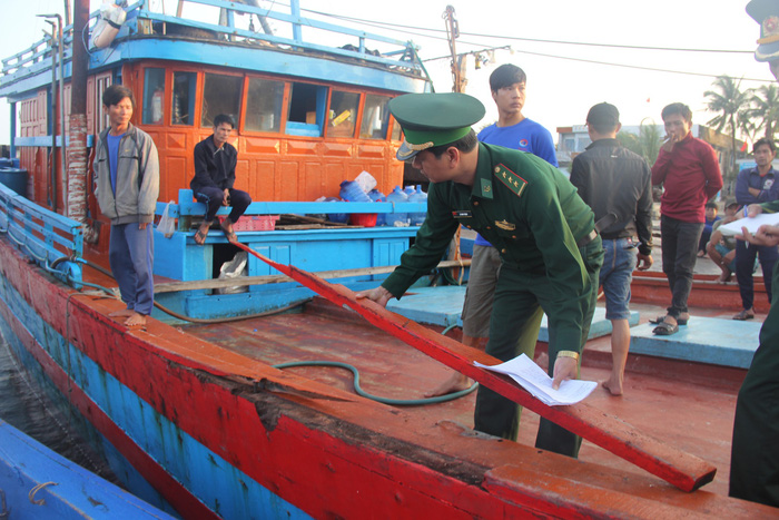 Officers assess the damage on two Vietnamese fishing ships after they were attacked by Chinese vessels near Hoang Sa (Paracel) Islands in the East Vietnam Sea on March 22, 2018. Photo: Tuoi Tre