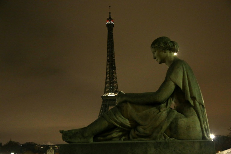 The Eiffel Tower dims its lights to honour the victims. Photo: AFP