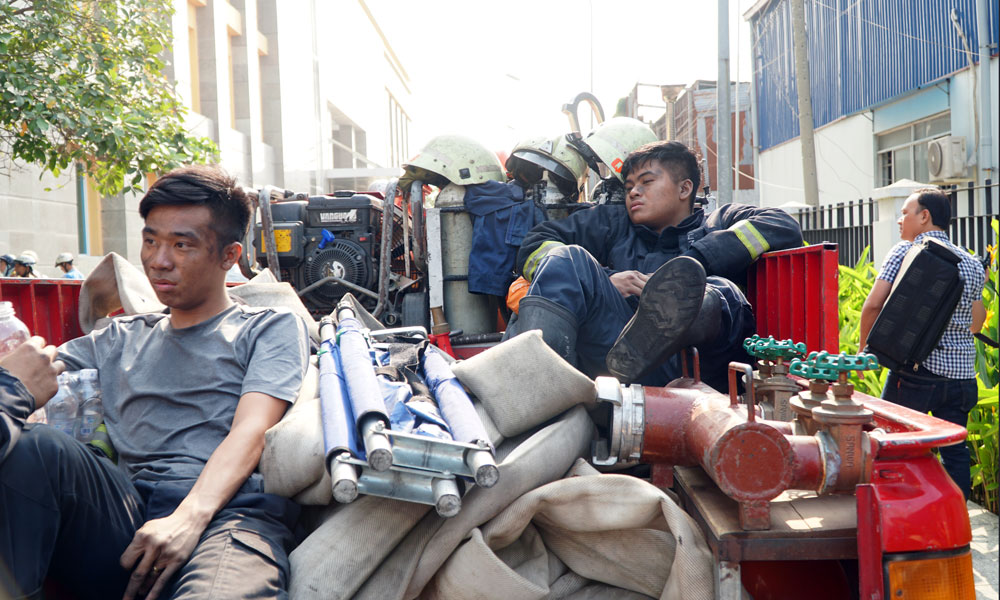 Firefighters take a rest after the fire is put out. Photo: Vietnamnet