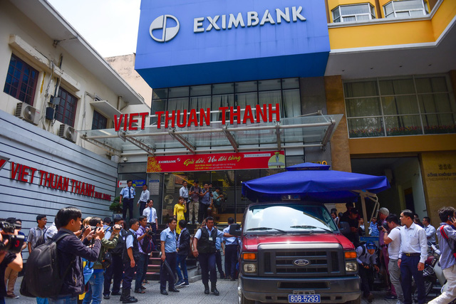 Police escort two arrested Eximbank employees in Ho Chi Minh City on March 26, 2018. Photo: Tuoi Tre