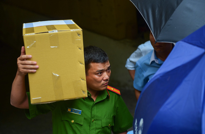 A police officer holds a box of documents seized after searching an Eximbank branch in Ho Chi Minh City on March 26, 2018. Photo: Tuoi Tre