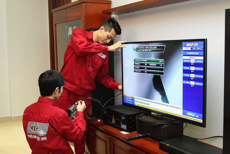 Two engineers set up VTVCab for a home TV in Vietnam. Photo: VTV