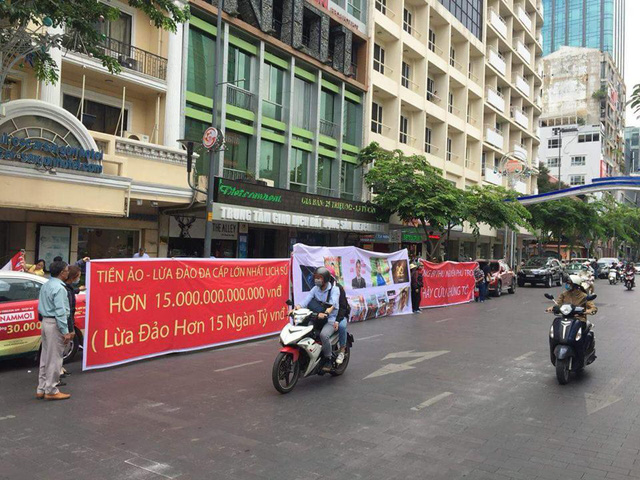 Victims of the scam hold a protest sign in front of the Modern Tech headquarters in Ho Chi Minh City on April 8, 2018. Photo: Tuoi Tre