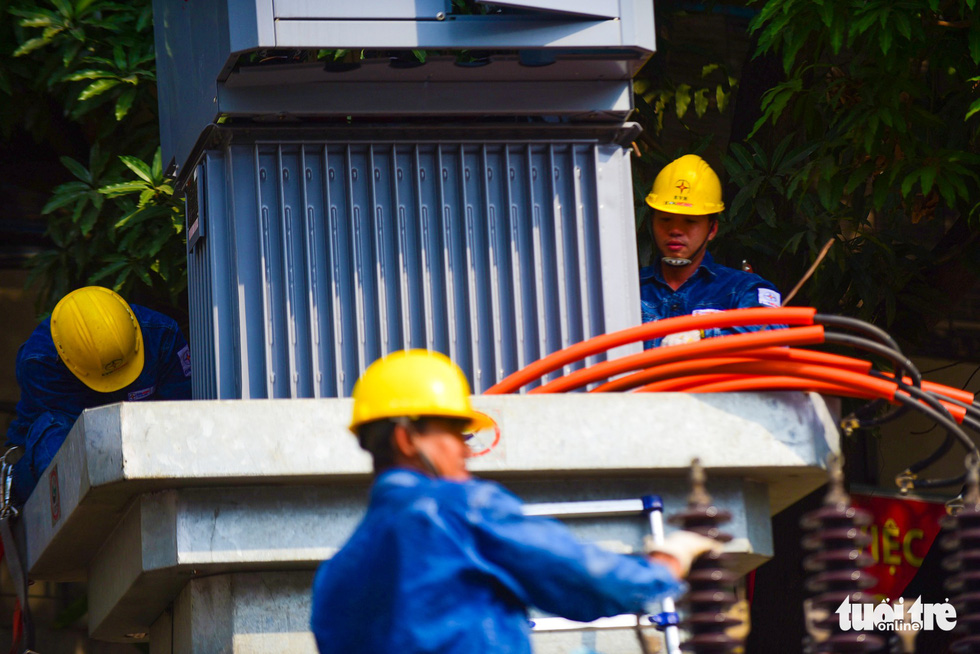 Workers repair a substation in Binh Thanh District to ensure power supply for local residents during the hot weather.