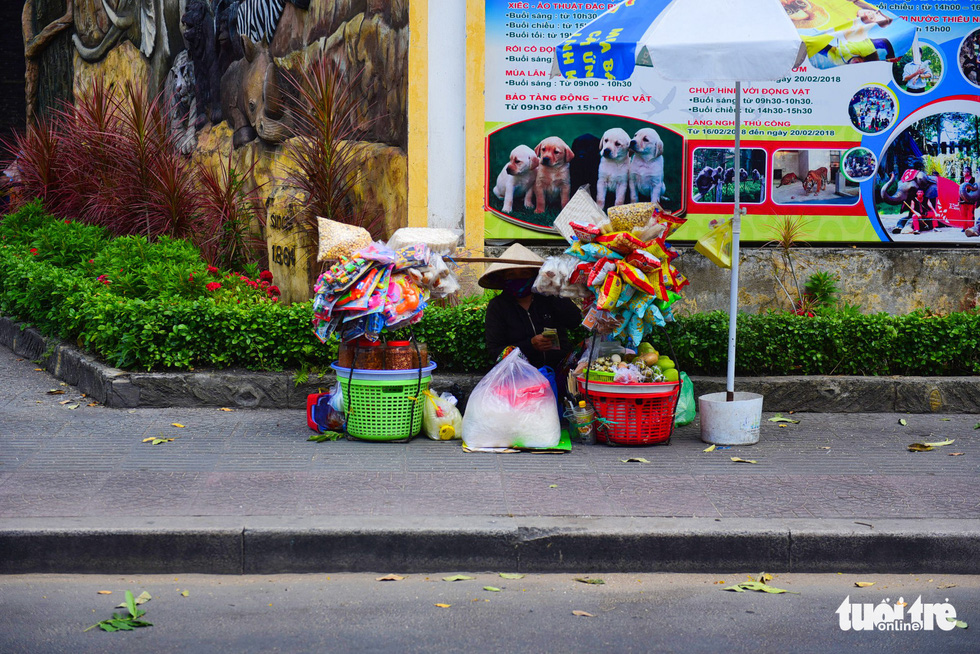 A street vendor sits on the sidewalk of Nguyen Thi Minh Khai Street in District 1.
