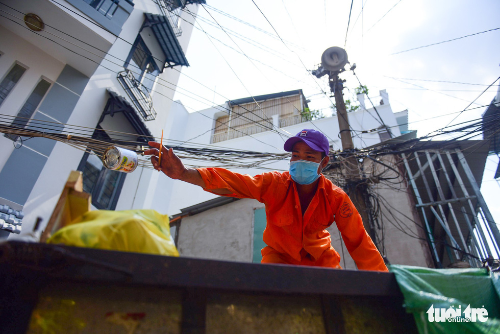 A garbage collector endures the scorching heat to finish his job on Van Kiep Street, Binh Thanh District.