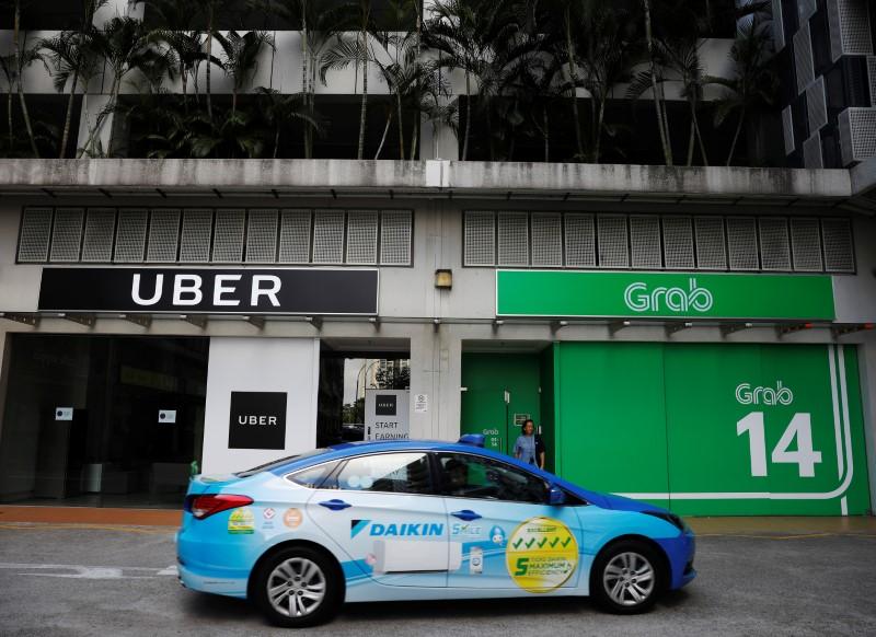 A ComfortDelgro taxi passes Uber and Grab offices in Singapore March 26, 2018. Photo: Reuters