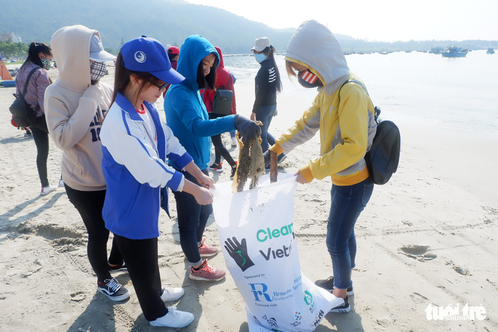 Students put garbage in a bag at a beach in Da Nang, central Vietnam, on April 22, 2018. Photo: Tuoi Tre