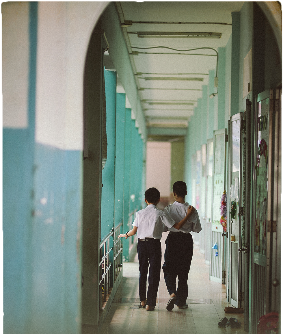Two students help each other walk forward along a corridor at Nguyen Dinh Chieu High School for the Visually Impaired. Photo: Tuoi Tre