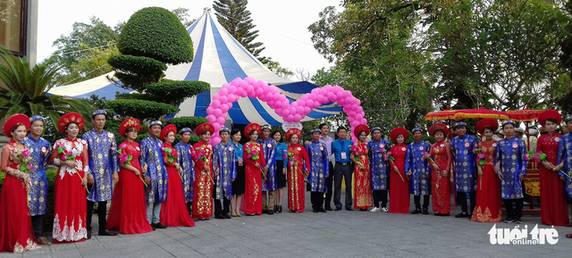 The twelve couples take a picture together to commemorate their grand moment. Photo: Tuoi Tre