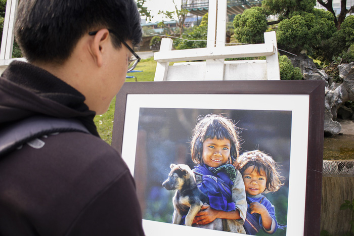 A young guy pays attention to a masterpiece featuring two little girls. Photo: Tuoi Tre
