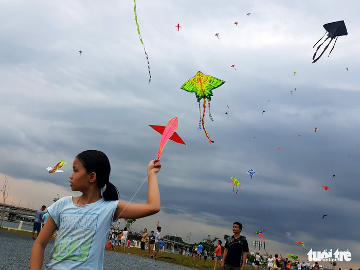 A baby girl smiles when her kite takes off. Photo: Tuoi Tre