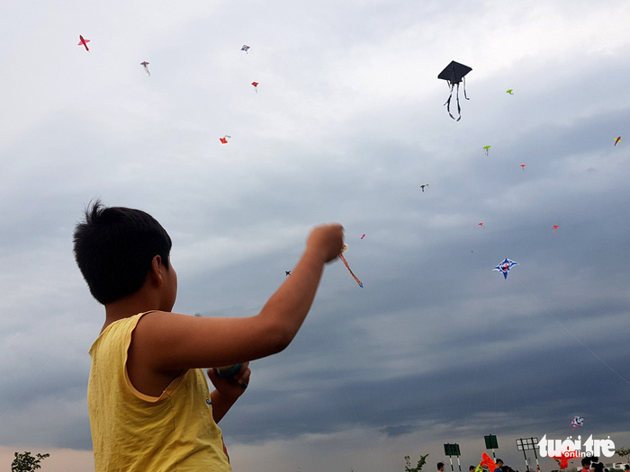 A little boy gazes at his flying kite. Photo: Tuoi Tre