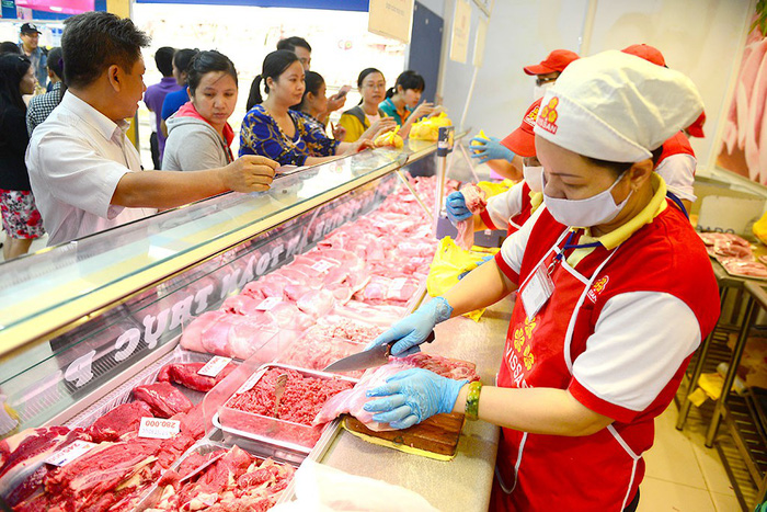 A supermarket worker sells frozen meat to customers. Photo: Tuoi Tre