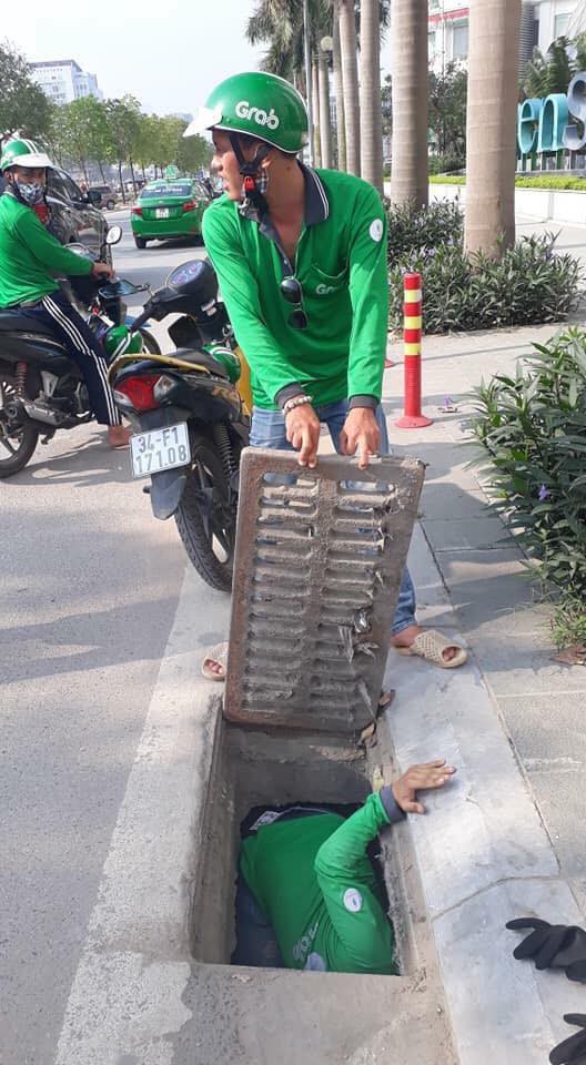 The GrabBike drivers are pictured trying to retrieve the bank card for Albany Owens from a drain in Hanoi in this photo posted on her Facebook on May 8, 2018.