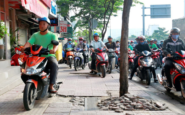 Motorbikes run during congestion on the sidewalk of Pham Van Dong Boulevard in Ho Chi Minh City, Vietnam. Photo: Tuoi Tre