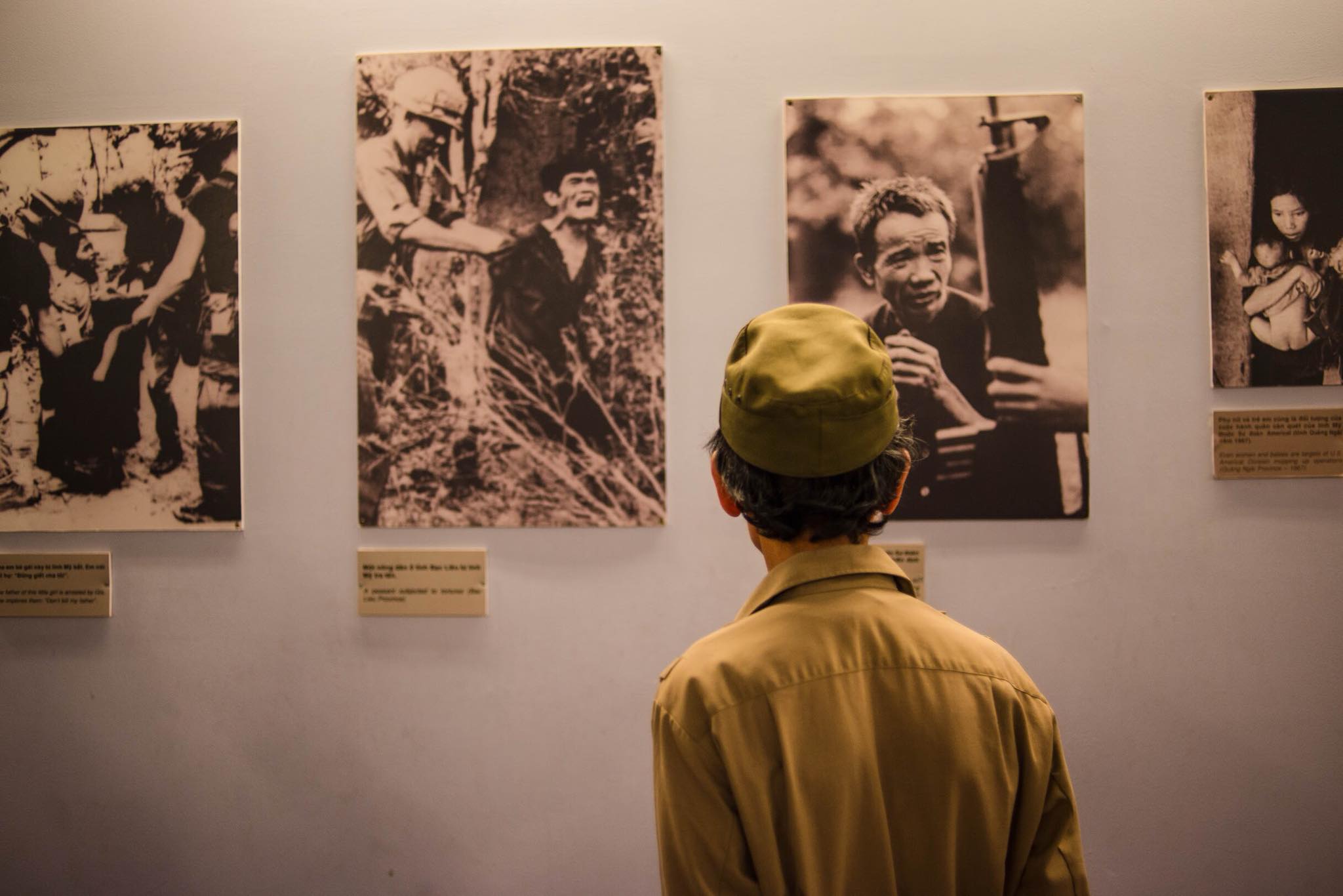 A veteran watches war pictures on display at a museum in Ho Chi Minh City. Photo: Humans of Saigon