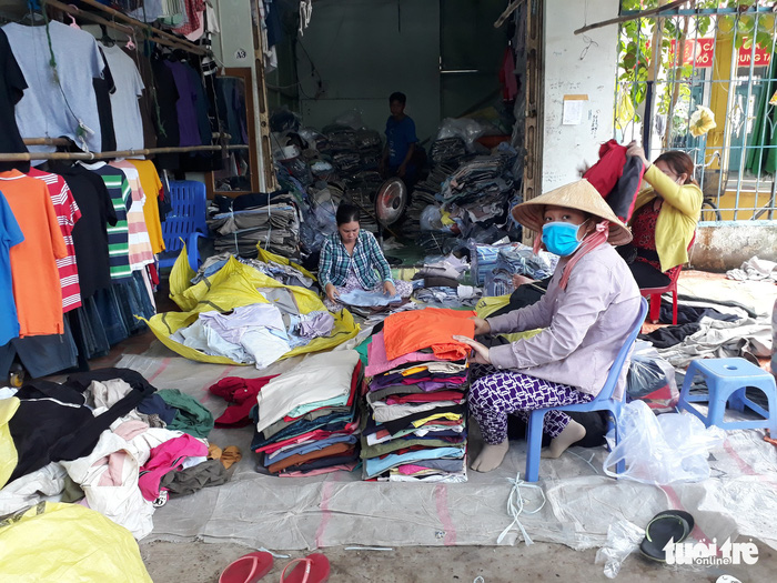 Women fold up clothes at the Chau Long Market in An Giang Province, southern Vietnam. Photo: Tuoi Tre