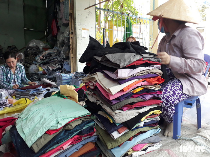 Women fold up clothes at the Chau Long Market in An Giang Province, southern Vietnam. Photo: Tuoi Tre