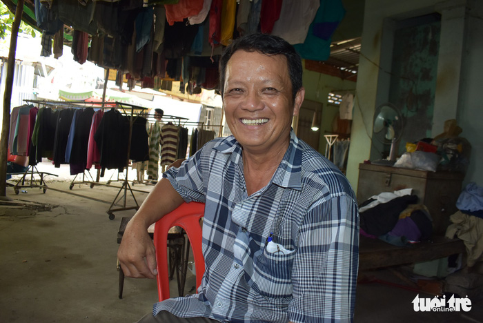 Huynh Van Mien poses for photos while wearing a secondhand shirt which he says fetches under VND50,000 (US$2.2), at the Chau Long Market in An Giang Province, southern Vietnam. Photo: Tuoi Tre