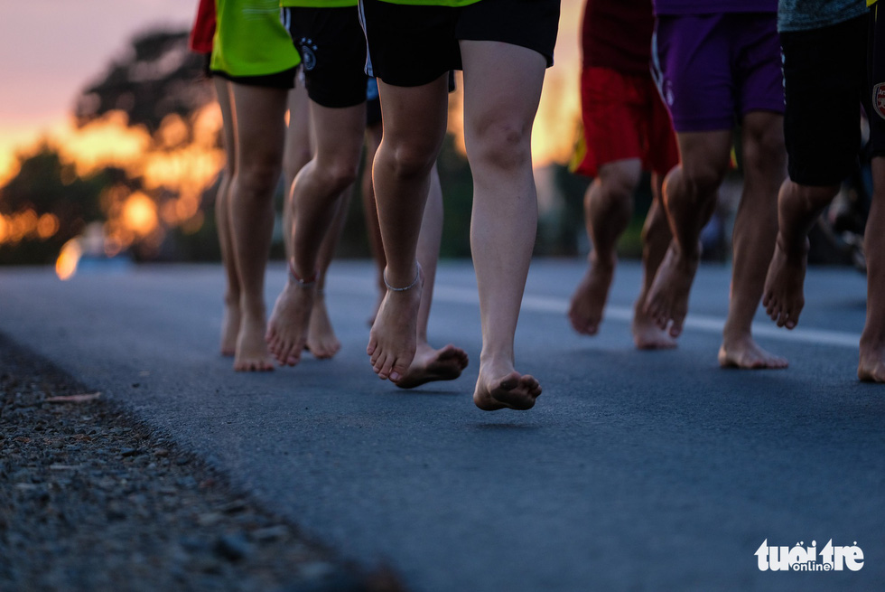 Young runners train barefoot along a local street. Photo: Tuoi Tre