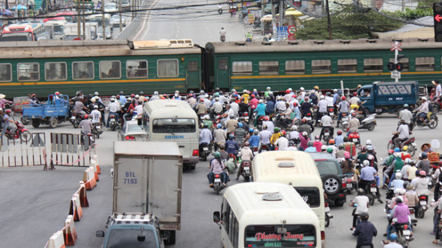 Vehicles wait for a train to pass in Ho Chi Minh City, Vietnam. Photo: Tuoi Tre