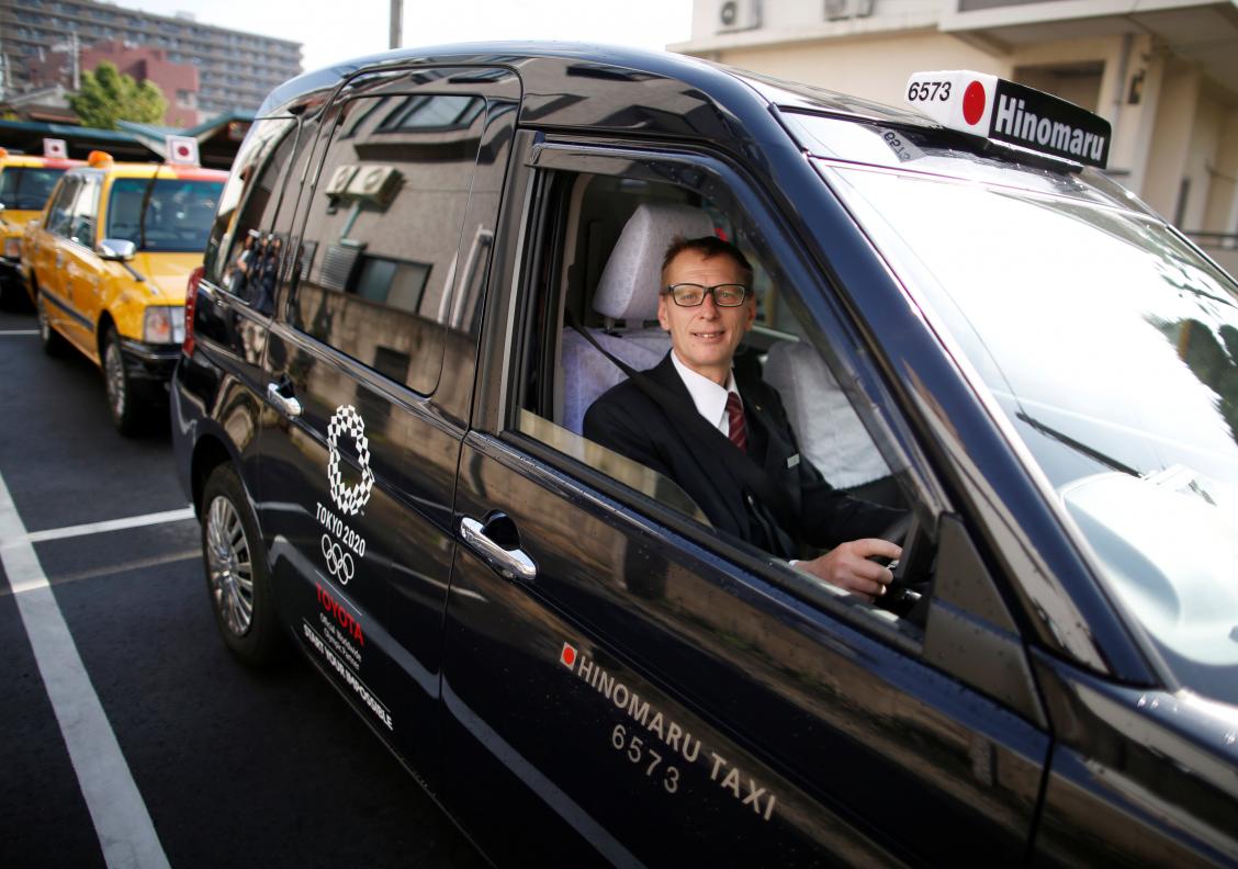 Wolfgang Loeger from Austria, a taxi driver of Hinomaru Kotsu Co., poses for a photograph inside a 'JPN Taxi' car, developed by Toyota Motor Co., in Tokyo, Japan May 14, 2018. Picture taken May 14, 2018. Photo: Reuters