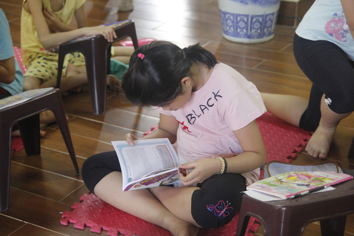A students indulges in the book she has just been awarded. Photo: Tuoi Tre