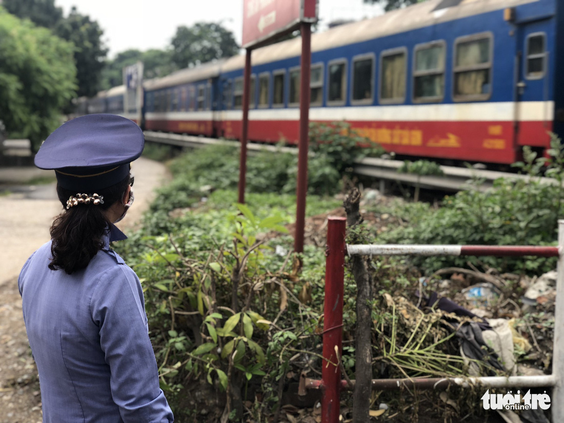 An attendant looks as a train passses a level crossing in Hanoi. Photo: Tuoi Tre
