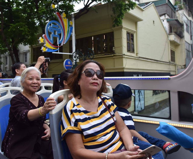 Passengers sit on the top floor of a double-decker in Hanoi, Vietnam. Photo: Tuoi Tre