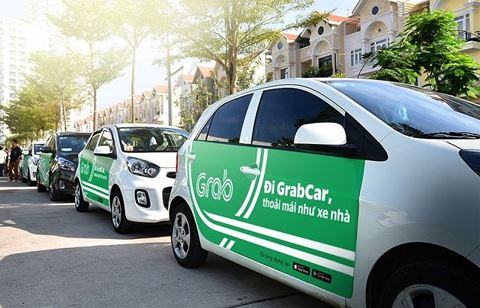 GrabCar taxis stop by the sidewalk in Ho Chi Minh City. Photo: Tuoi Tre