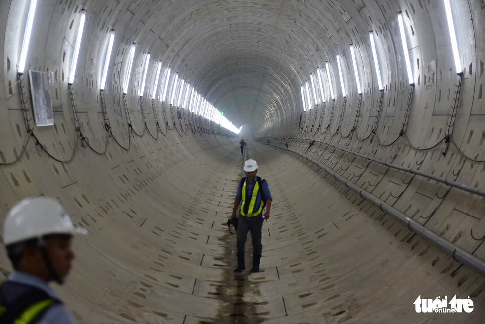 Workers walk inside an underground tunnel located beneath the downtown area of Ho Chi Minh City, where the future metro line will travel. Photo: Tuoi Tre