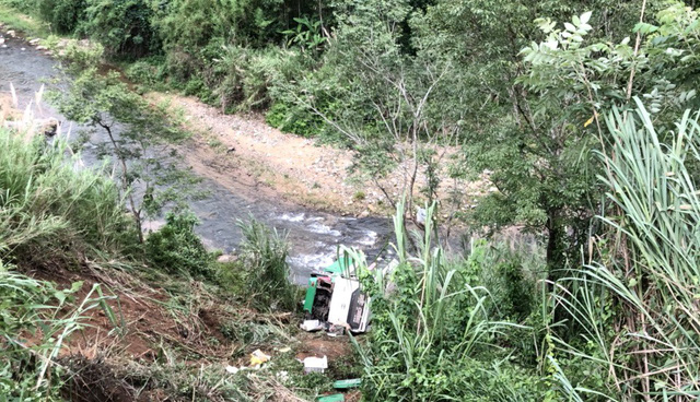 A coach lies overturned in a shallow river along the Ho Chi Minh Highway section in Kom Tum Province, Vietnam, after careering down a bank on June 16, 2018. Photo: Tuoi Tre