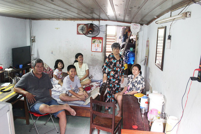 Nguyen Minh Tri (foreground) and his family pose for photos in his house along the Doi Canal in District 8, Ho Chi Minh City, Vietnam. Photo: Tuoi Tre