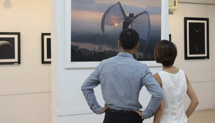 Nhung and her fiancé watch a photo on display at