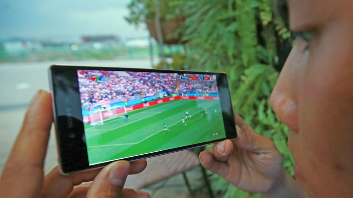 A Vietnamese fan watches a World Cup 2018 match on his mobile phone. Photo: Tuoi Tre