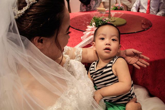 A bride holds her son during the special event. Photo: Tuoi Tre