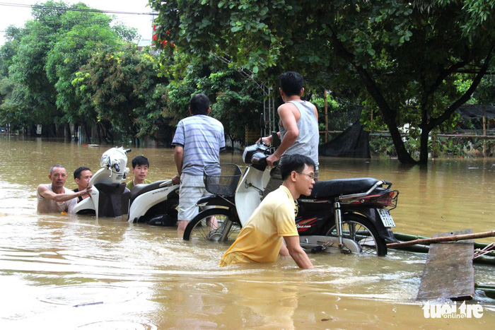 Residents struggle to travel on a inundated street in Ha Giang Province.