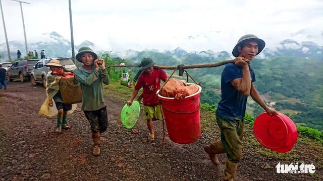People from Sang Tung Village in Lai Chau carry their belongings to temporary homes after a landslide buried their entire village on June 27.