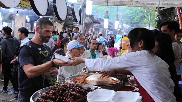 A foreign tourist visits a food fair in Vietnam. Photo: Tuoi Tre