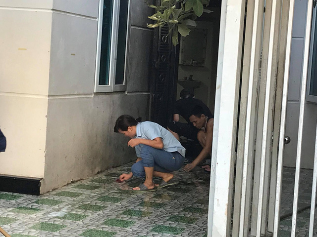 Men clean specks of blood at a victim’s house in Hanoi, Vietnam, July 3, 2018. Photo: Tuoi Tre