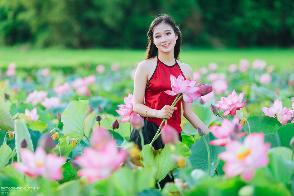 A girl primps among the lotus flowers
