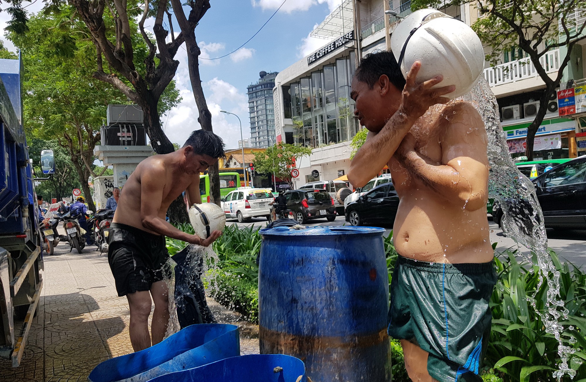 Drainage workers wash themselves along a street in Ho Chi Minh City, Vietnam. Photo: Tuoi Tre