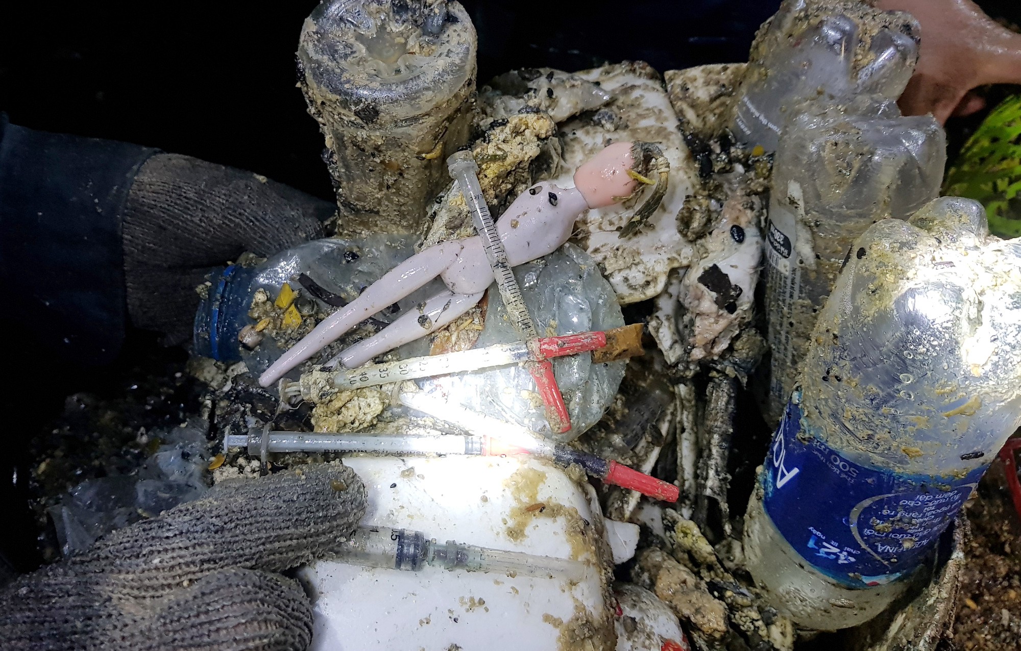 Syringes and plastic items are seen in a sewage pipe in Ho Chi Minh City, Vietnam. Photo: Tuoi Tre
