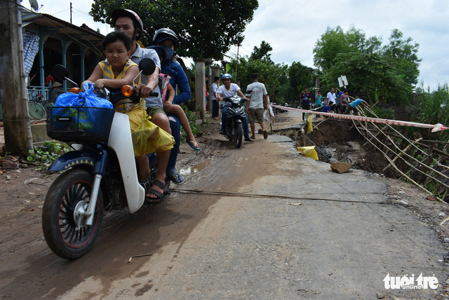 A motorcycle runs on an eroded road in An Giang Province, Vietnam, June 3, 2018. Photo: Tuoi Tre