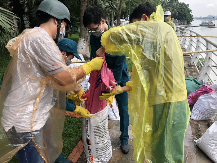 Workers place dead fish into a bag at Ho Tay (West Lake) in Hanoi, Vietnam, July 9, 2018. Photo: Tuoi Tre