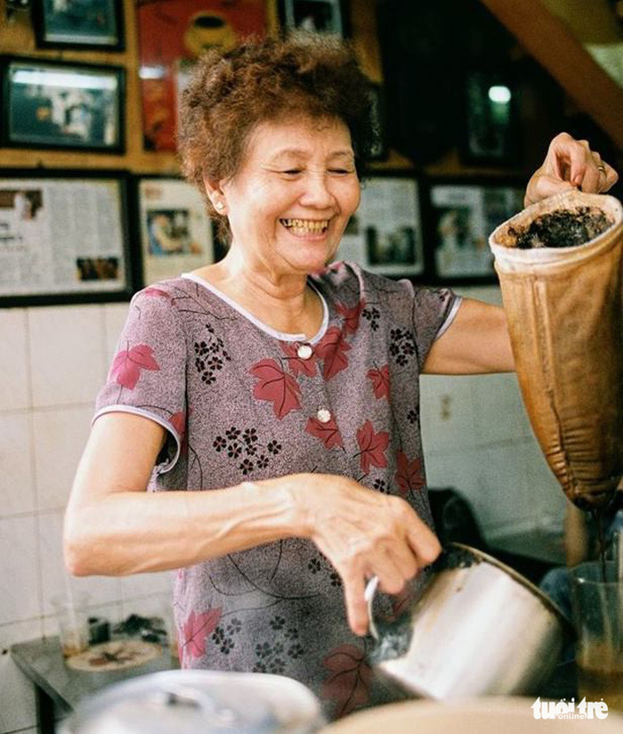 Tuyet, the owner’s wife and currently main barista of the coffee shop, smiles as she brews coffee for customers. Photo: Tuoi Tre