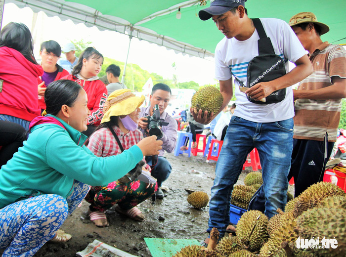 One visitor picks a ripe durian and asks a staff member to open it. Photo: Tuoi Tre