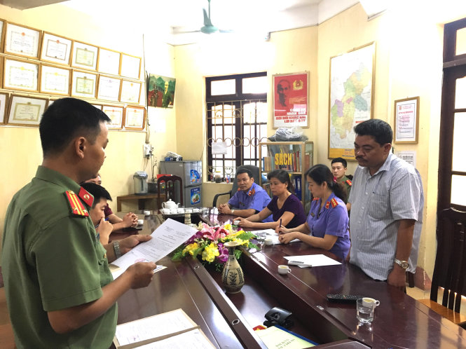 Nguyen Thanh Hoai (R), head of testing and quality assurance under Ha Giang Province’s Department of Education and Training, listens as a police officer reads his detention order on July 23, 2018. Photo: Tuoi Tre