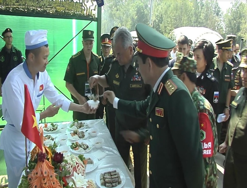 Russian Minister of Defense Sergey Shoygu has a taste of a Vietnamese dish during the field kitchen competition.  Photo: Vietnam News Agency
